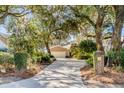 Brick home with large front yard framed by moss-draped trees and verdant landscaping at 119 Riverland Dr, Charleston, SC 29412