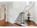 Bright foyer with curved staircase featuring white railings, gray carpet, and dark wood floors at 121 Jakes Ln, Mount Pleasant, SC 29464