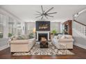 Cozy living room featuring a fireplace, comfortable seating, and natural light from large windows at 121 Warbler Way, Summerville, SC 29483