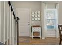 Bright entryway featuring hardwood floors, a decorative table with gold mirrors, and natural light from the window at 127 Surfbird Rd, Summerville, SC 29486