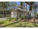 Beautiful home featuring an attached garage, a manicured lawn, and mature trees at 161 Marsh Hawk Ln, Kiawah Island, SC 29455
