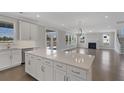 Bright, open-concept kitchen featuring white cabinets, an island, hardwood floors, and stainless appliances at 2006 Riverbend Dr, Charleston, SC 29412