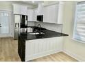 Modern kitchen boasts white cabinets, granite countertops, and stainless steel appliances at 2035 Beech Ave, North Charleston, SC 29405