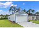 Exterior view showcasing the home's siding, an attached two-car garage, and a well-kept lawn at 206 Pine Crest View Dr, Summerville, SC 29486