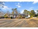 Inviting single-story brick home showcasing a well-kept lawn and tasteful landscaping, blending charm and comfort at 209 E 4Th S St, Summerville, SC 29483