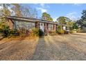 Charming brick home with a well-maintained lawn, complemented by lush landscaping and a welcoming entrance at 209 E 4Th S St, Summerville, SC 29483