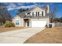 Inviting two-story home showcasing a spacious driveway and neutral siding against a blue sky at 215 Evesham Dr, Summerville, SC 29485