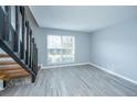 View of living room featuring a staircase, tile flooring, a window, and light blue walls at 2494 Etiwan Ave # B-4, Charleston, SC 29414