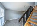 View of living room with stairway, light grey walls, light fixtures, and modern flooring at 2494 Etiwan Ave # B-4, Charleston, SC 29414
