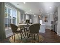 Bright dining area with a circular rug, view of the backyard and a pass-through to the kitchen at 306 O'Malley Dr, Summerville, SC 29483