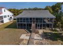 Charming beach house with screened porch, wooden walkway and stairs leading to the entrance at 3408 Palmetto Blvd, Edisto Island, SC 29438