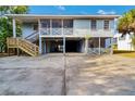 Coastal home featuring ample covered parking space and a wooden staircase to the main entrance at 3408 Palmetto Blvd, Edisto Island, SC 29438