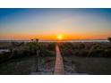 Breathtaking sunset view over the ocean from the backyard, with a wooden walkway leading to the beach at 3408 Palmetto Blvd, Edisto Island, SC 29438