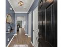 Elegant foyer with hardwood floors, modern light fixture, and an inviting view into the living spaces at 407 Squire Pope Rd, Summerville, SC 29486