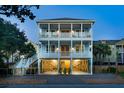 Three-story coastal home with double porches, convenient ground-level parking and great lighting for evening ambiance at 74 Sandbar Ln, Folly Beach, SC 29439