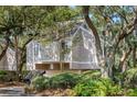 Charming raised home featuring a neutral exterior, lush landscaping, and inviting staircase at 807 Treeloft Trce, Seabrook Island, SC 29455
