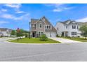 Street view of a two-story home with a well-manicured lawn and inviting curb appeal at 9998 Winged Elm St, Ladson, SC 29456