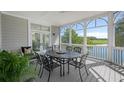 Relaxing screened porch with outdoor dining set, providing views of the water and a serene environment at 10 Ocean Point Dr, Isle of Palms, SC 29451
