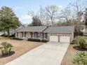 Beautiful brick home features an attached two-car garage and a long driveway bordered by manicured landscaping at 1043 Dominion Dr, Hanahan, SC 29410