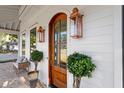 Elegant arched wood front door with decorative sidelights and potted greenery at 1119 Simmons St, Mount Pleasant, SC 29464