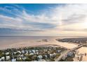 A scenic aerial view of a charming coastal neighborhood with waterfront homes, beaches, and lush greenery at 112 Ocean Blvd, Isle of Palms, SC 29451