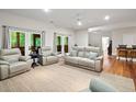 Spacious living area with comfortable seating, a ceiling fan, and access to the outdoors through double doors at 140 Old Plantation Ln, Moncks Corner, SC 29461