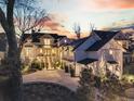 Luxurious white farmhouse with a driveway, meticulous landscaping, and warm lighting at 151 Brailsford St, Charleston, SC 29492