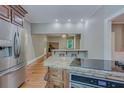 Well-equipped kitchen with stainless steel refrigerator, island cooktop, and breakfast bar at 1860 Pinopolis Rd, Pinopolis, SC 29469