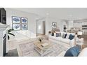 Bright living room with modern furniture, stylish decor, and an open concept layout to the kitchen at 207 Denham St, Summerville, SC 29486