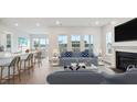Bright living room with a fireplace, large windows, and an open concept design into the kitchen at 230 Denham St, Summerville, SC 29486