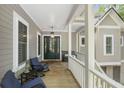 Inviting front porch features comfortable seating, stylish decor, and views of the home's exterior at 2932 Old Drake Dr, Seabrook Island, SC 29455