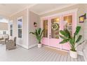 Inviting front porch features pink double doors with glass, plants, and outdoor seating at 3587 Clambank Dr, Mount Pleasant, SC 29466