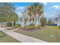 Inviting yellow home with a charming front porch and well-maintained landscaping on a sunny day at 3713 Maidstone Dr, Mount Pleasant, SC 29466