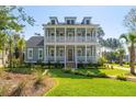 Inviting two-story house with double porches and manicured front yard, blending classic design with outdoor charm at 3859 Segars Lndg, Mount Pleasant, SC 29466