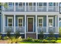 Detailed view of the home's charming front porch, framed by columns and railing, and a dark wood door at 3859 Segars Lndg, Mount Pleasant, SC 29466