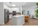 Modern kitchen with stainless steel appliances, a center island, and an adjacent dining area and bedroom at 1025 Riverland Woods Pl # 608, Charleston, SC 29412
