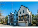 Street view of modern three-story townhomes featuring brick and blue siding with attached garages at 1641 Florentia St, Mount Pleasant, SC 29464