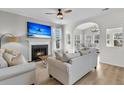 Cozy living room with a fireplace, large TV, comfortable seating, and an arched opening to another living space at 1821 Great Hope Dr, Mount Pleasant, SC 29466