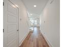 Bright hallway with hardwood floors, white walls, and staircase leading to the upper level at 219 Clearblue Loop, Summerville, SC 29486