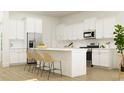 Modern kitchen with stainless steel appliances, white cabinetry, an island with bar seating, and tile backsplash at 233 Denham St, Summerville, SC 29486