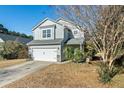 Charming two-story home with light gray siding, white garage door and blue sky at 243 Clayburne Dr, Goose Creek, SC 29445