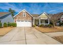 Inviting home with a stone facade, a two-car garage, and a quaint front porch at 3034 Cross Vine Ln, Summerville, SC 29483