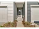 Inviting front entrance with blue siding, a gray front door and a view of the garage doors to the left at 3066 Emma Ln, Mount Pleasant, SC 29466