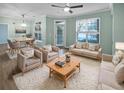 Bright living and dining room with hardwood floors, ceiling fan, neutral furniture, and access to screened balcony at 45 Sycamore Ave # 1413, Charleston, SC 29407