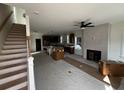 Unfinished open-concept living space with a fireplace, stairs, and kitchen area at 515 Joseph St, Charleston, SC 29412