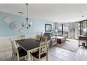 Open-concept living room with large windows and a dining area featuring neutral paint and tile floors at 8000 Palmetto Dr # 103-A, Isle of Palms, SC 29451