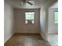 Inviting living area with tan tile flooring, a ceiling fan, and a convenient window air conditioning unit at 103 Cooper St, Charleston, SC 29403