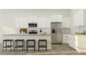 Modern kitchen with white cabinets, stainless steel appliances, a stylish breakfast bar, and wood flooring at 1154 Darling St, Summerville, SC 29485