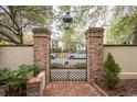 Wrought iron garden gate with brick pillars, offering privacy and curb appeal at 121 Shipyard Rd, Mount Pleasant, SC 29464