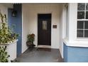 Inviting front door featuring a dark wood door with decorative glass, accented by plants and exterior lighting at 1216 Eastwood Ave, Hanahan, SC 29410